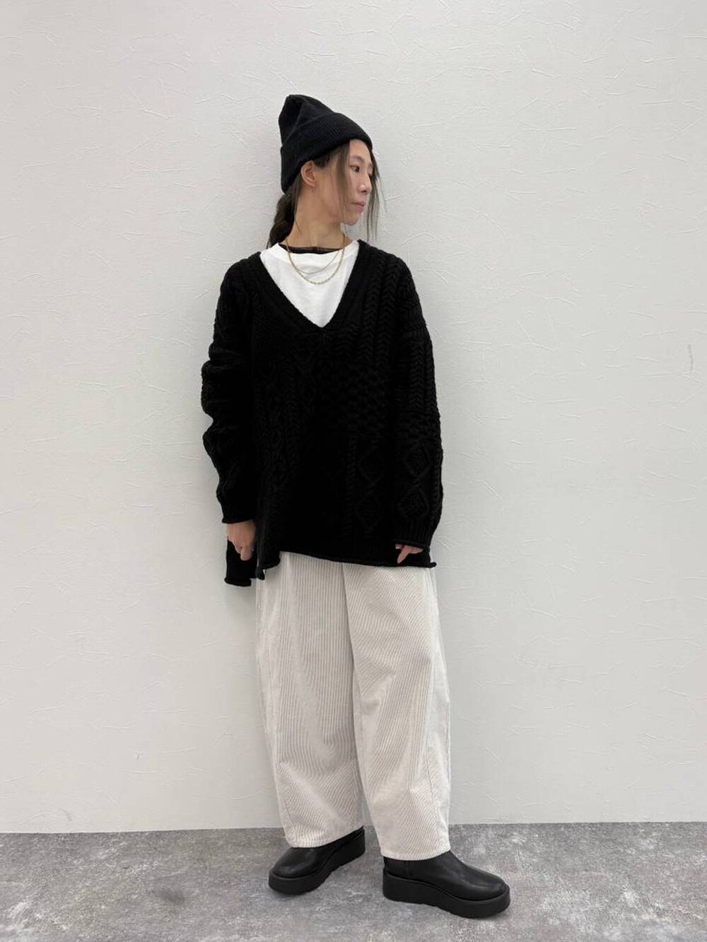 ブラック系のブーツ、グレー系のその他パンツ、ホワイト系のTシャツ/カットソーを着用したレディースの冬コーディネートの2枚目の写真