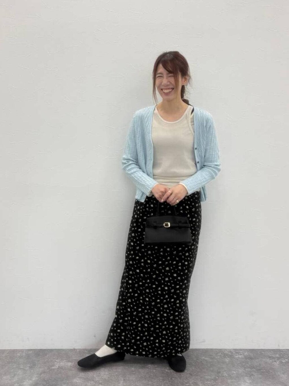 ブラック系のショルダーバッグ、グレー系のパンプス、ベージュ系のTシャツ/カットソーを着用したレディースの春コーディネートの3枚目の写真