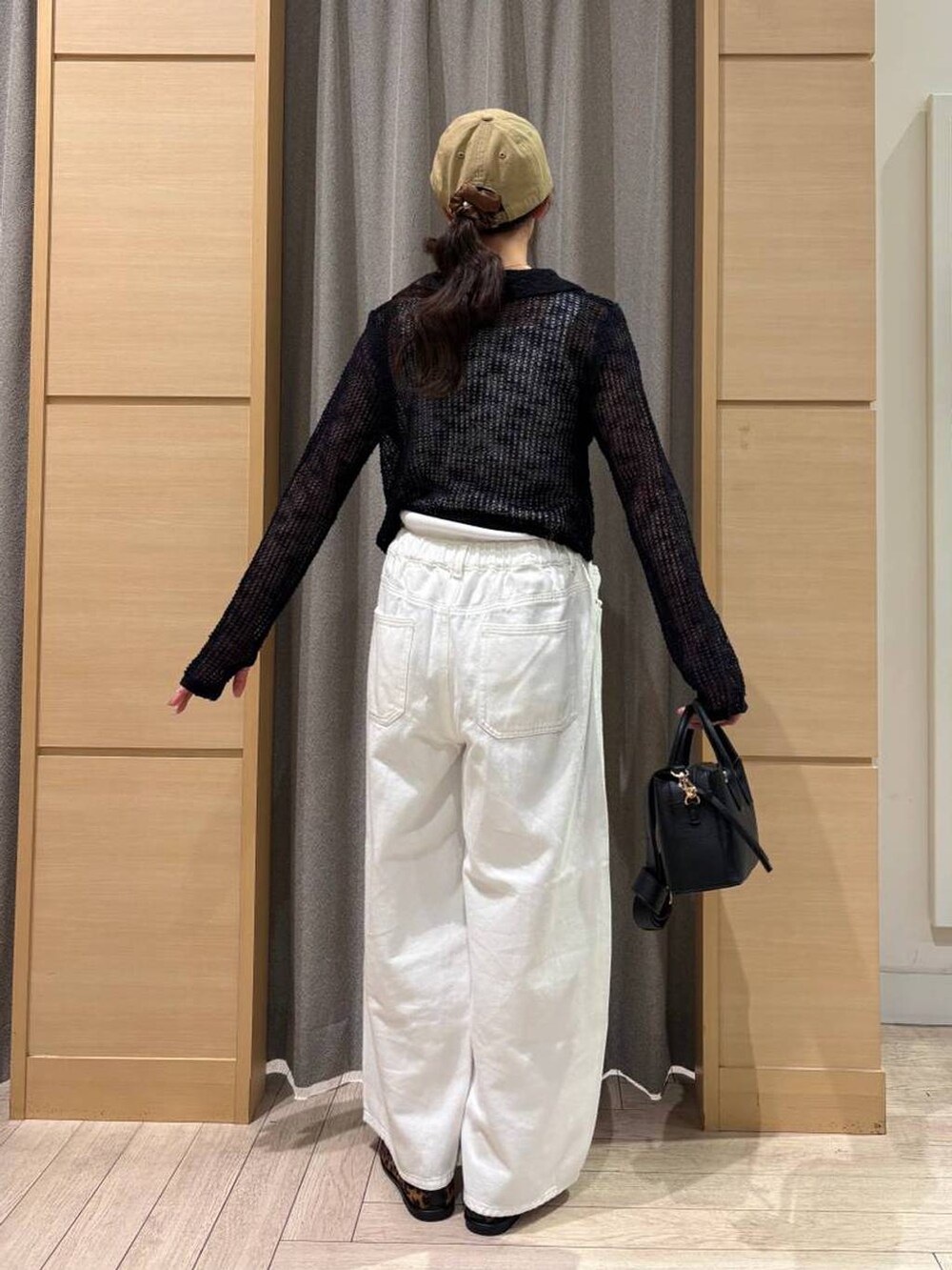 ホワイト系のデニムパンツ、ブラウン系のパンプス、ホワイト系のタンクトップを着用したレディースの春コーディネートの3枚目の写真