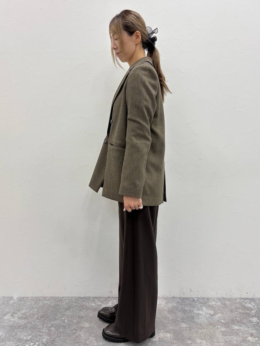 ブラウン系のテーラードジャケット、ホワイト系のシャツ/ブラウス、ブラウン系のローファーを着用したレディースの秋コーディネートの2枚目の写真