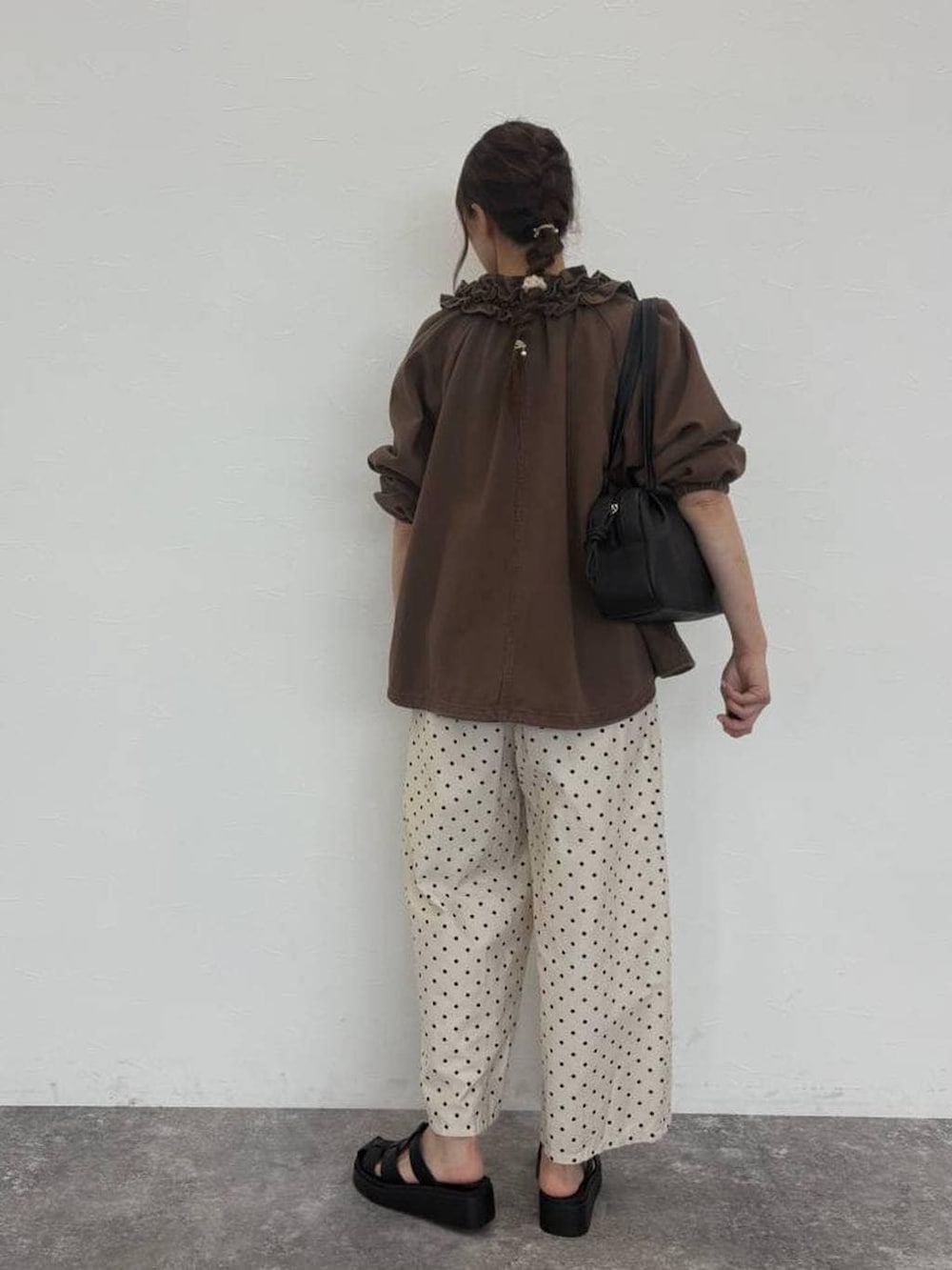 ブラック系のショルダーバッグ、ピンク系のTシャツ/カットソー、ブラウン系のブルゾンを着用したレディースの秋コーディネートの2枚目の写真