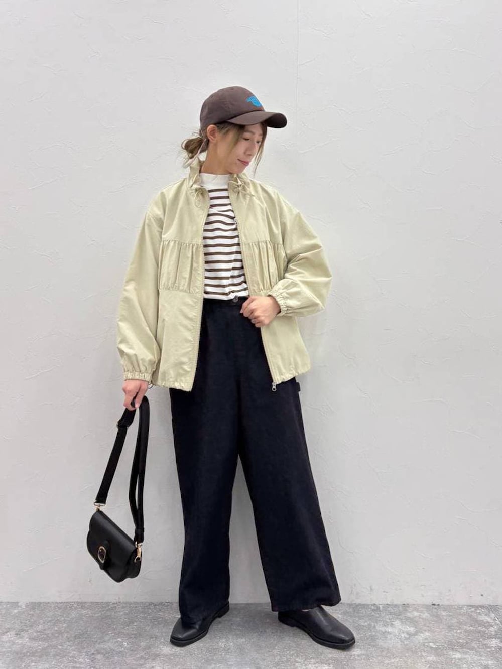 ブラック系のスリッポン、ブラック系のショルダーバッグ、ブルー系のその他パンツを着用したレディースの春コーディネートの3枚目の写真