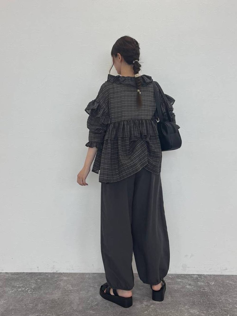 ブラック系のショルダーバッグ、グレー系のシャツ/ブラウス、ホワイト系のタンクトップを着用したレディースの秋コーディネートの2枚目の写真