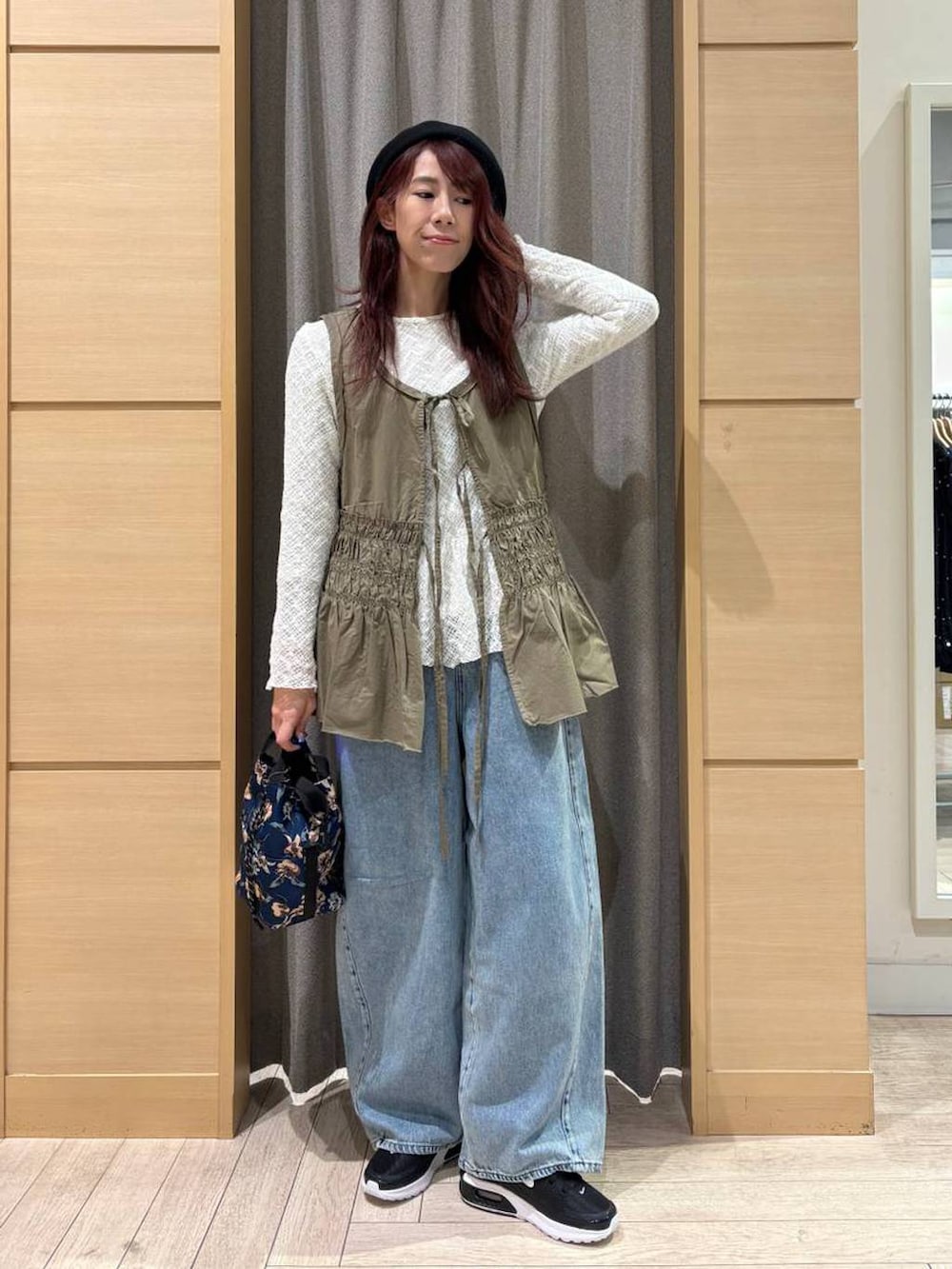 ブルー系のデニムパンツ、ホワイト系のTシャツ/カットソー、グリーン系のベストを着用したレディースの春コーディネートの4枚目の写真