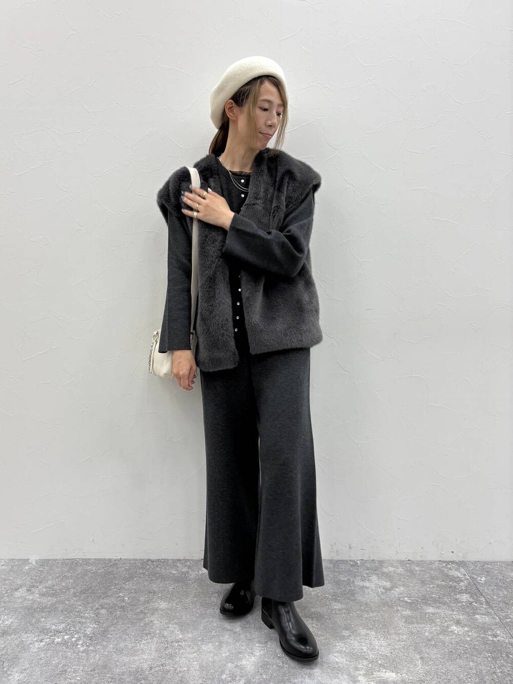 ブラック系のブーツ、ブラック系のTシャツ/カットソー、ベージュ系のショルダーバッグを着用したレディースの秋コーディネートの2枚目の写真