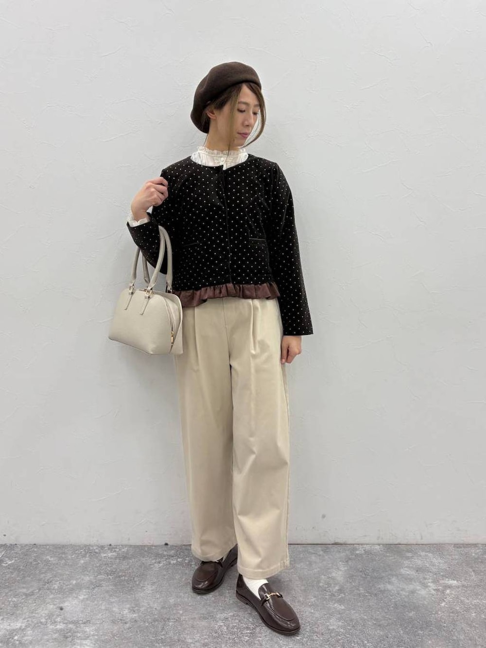 ベージュ系のスラックス、ベージュ系のトートバッグ、ホワイト系のシャツ/ブラウスを着用したレディースの冬コーディネートの4枚目の写真