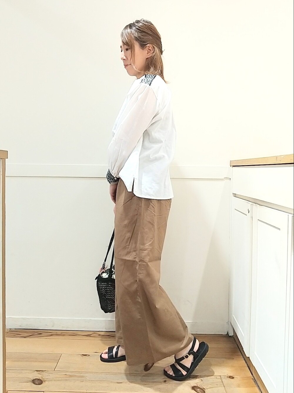 ホワイト系のシャツ/ブラウス、ブラウン系のその他パンツ、ブラック系のサンダルを着用したレディースの春コーディネートの2枚目の写真