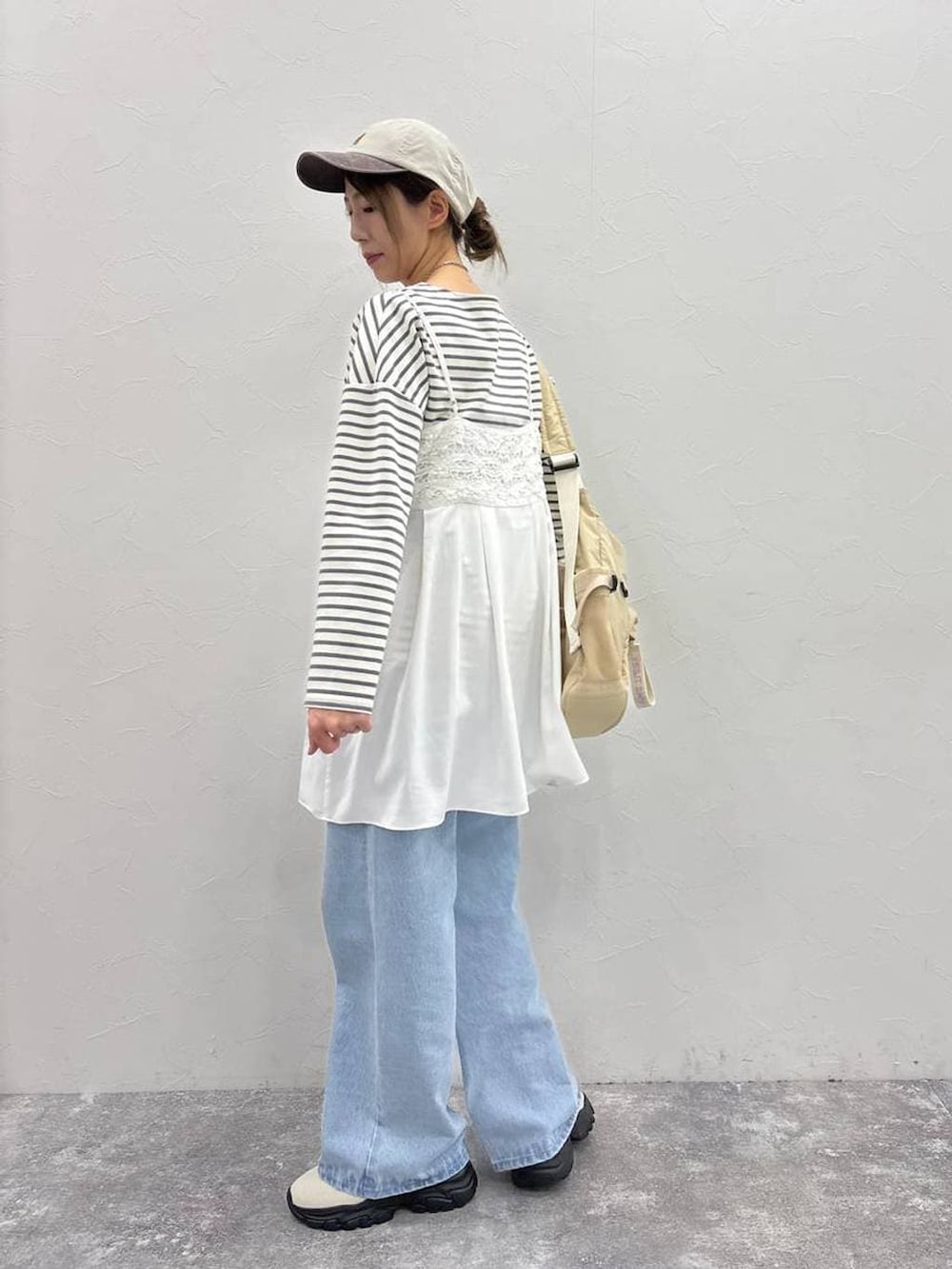 ホワイト系のスニーカー、その他のTシャツ/カットソー、ベージュ系のショルダーバッグを着用したレディースの春コーディネートの2枚目の写真