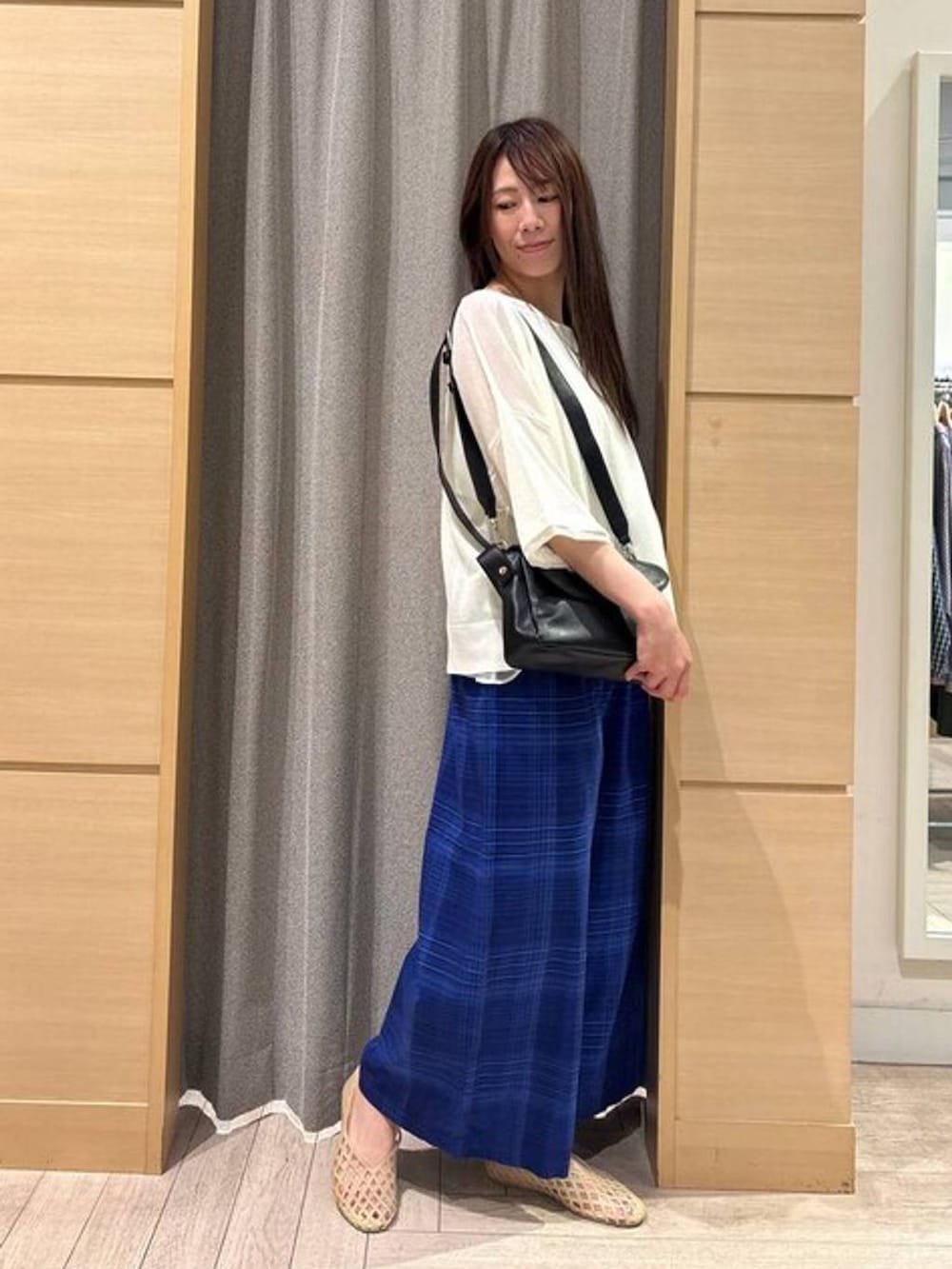 ベージュ系のパンプス、ブルー系のその他パンツ、ブラック系のショルダーバッグを着用したレディースの夏コーディネートの2枚目の写真
