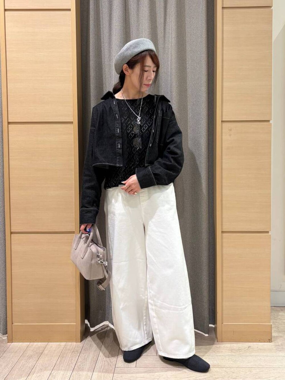 ホワイト系のデニムパンツ、グレー系のパンプス、ホワイト系のタンクトップを着用したレディースの春コーディネートの5枚目の写真