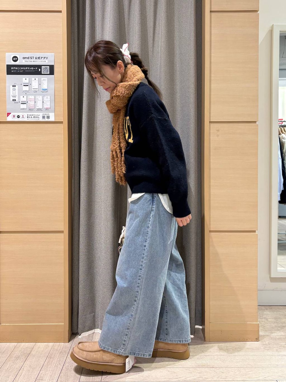 ブルー系のデニムパンツ、ベージュ系のブーツ、ベージュ系のショルダーバッグを着用したレディースの冬コーディネートの2枚目の写真