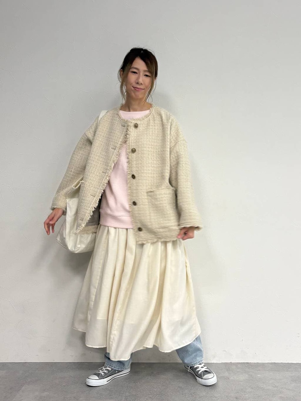 ブルー系のデニムパンツ、ベージュ系のスカート、ベージュ系のノーカラージャケットを着用したレディースの冬コーディネートの3枚目の写真