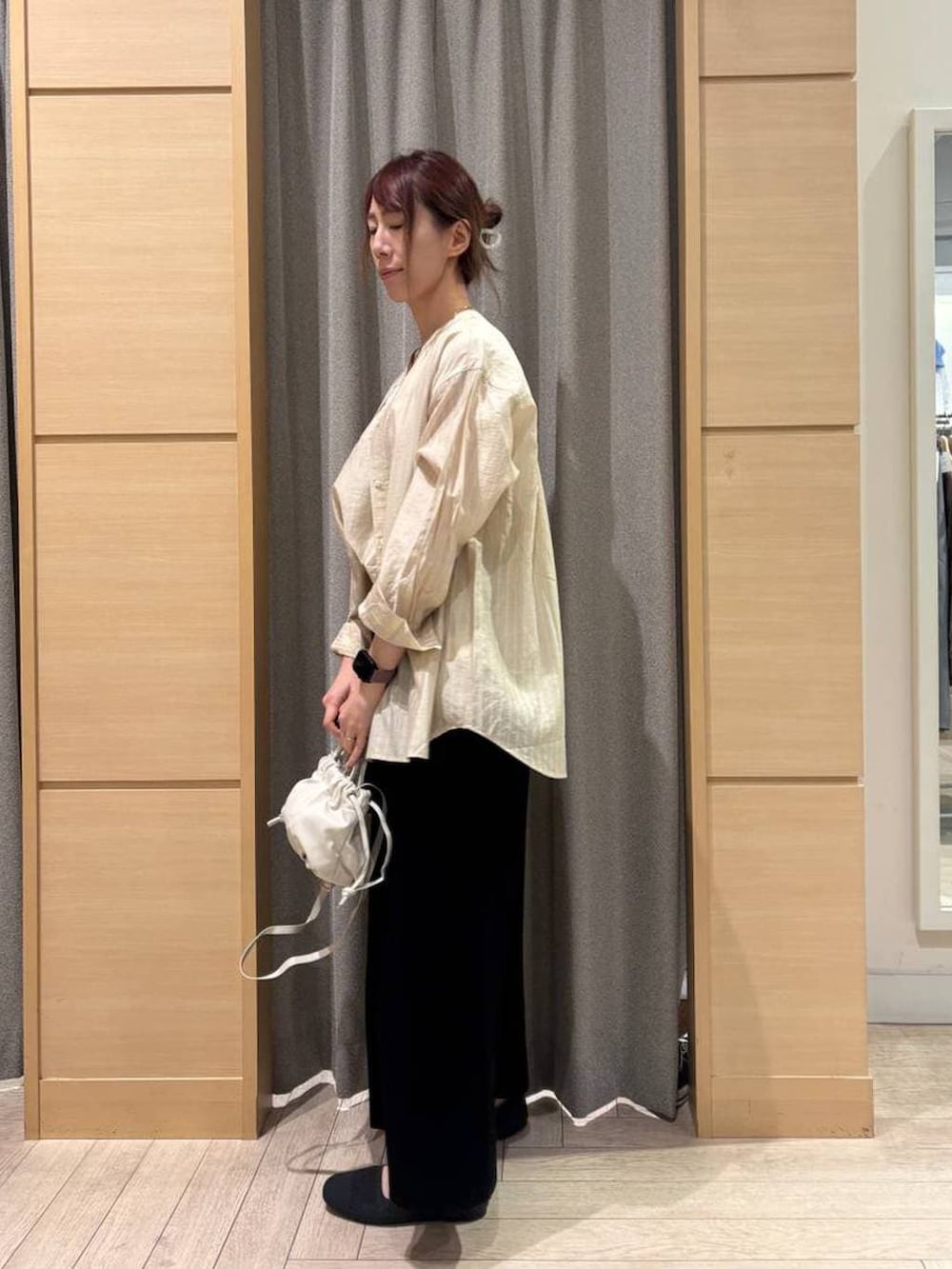 ブラック系のスカート、グレー系のパンプス、ホワイト系のタンクトップを着用したレディースの春コーディネートの3枚目の写真