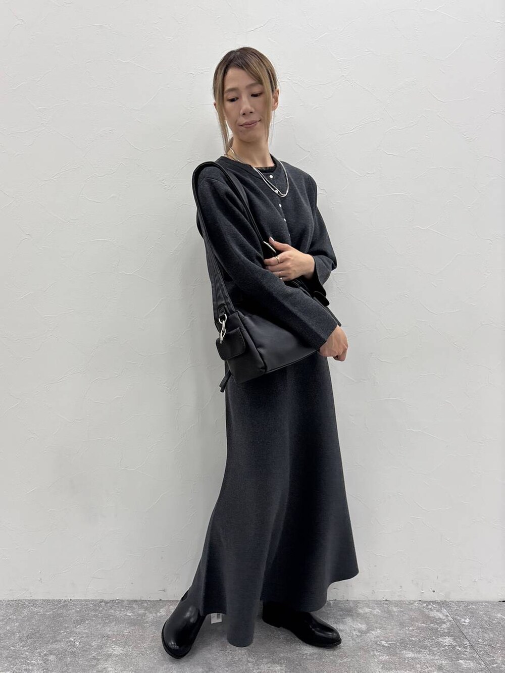 ブラック系のブーツ、ブラック系のTシャツ/カットソー、ブラック系のショルダーバッグを着用したレディースの秋コーディネートの4枚目の写真