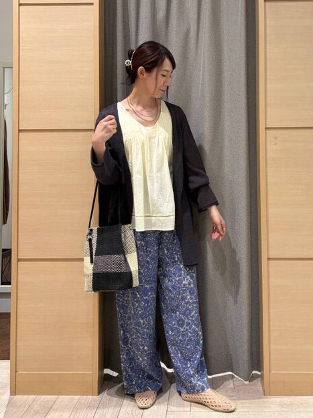 ブラック系のトートバッグ、ホワイト系のタンクトップ、ベージュ系のパンプスを着用したレディースの夏コーディネートの7枚目の写真