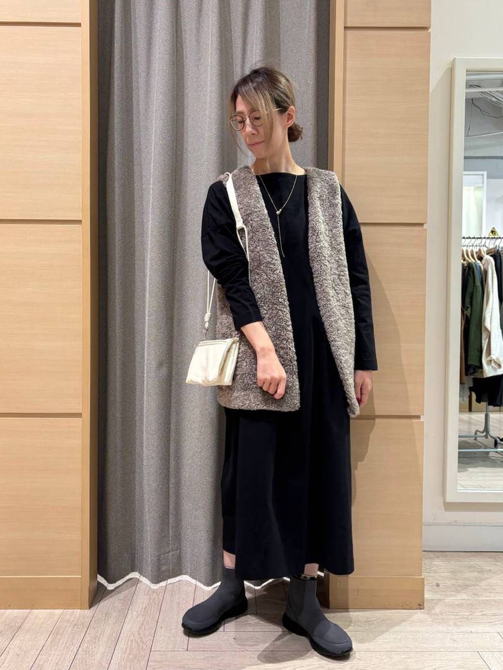 その他のベスト、グレー系のブーツ、ブラック系のショルダーバッグを着用したレディースの秋コーディネートの5枚目の写真