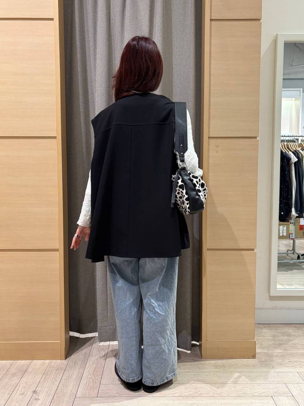 ブルー系のデニムパンツ、ブラック系のスニーカー、ホワイト系のTシャツ/カットソーを着用したレディースの春コーディネートの3枚目の写真