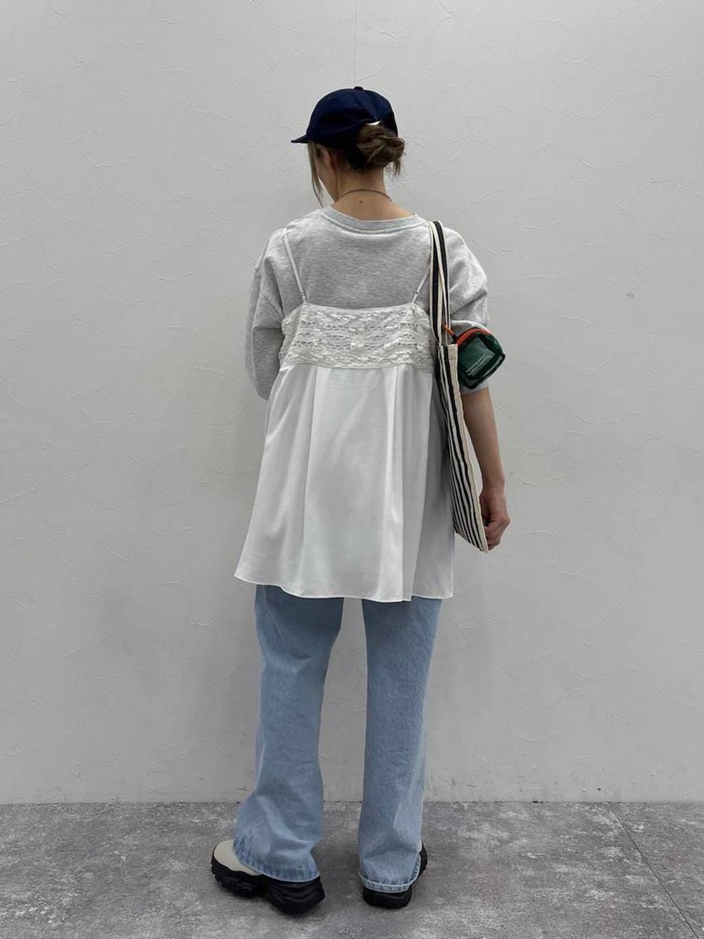 ホワイト系のスニーカー、グレー系のスウェット、ベージュ系のトートバッグを着用したレディースの春コーディネートの4枚目の写真