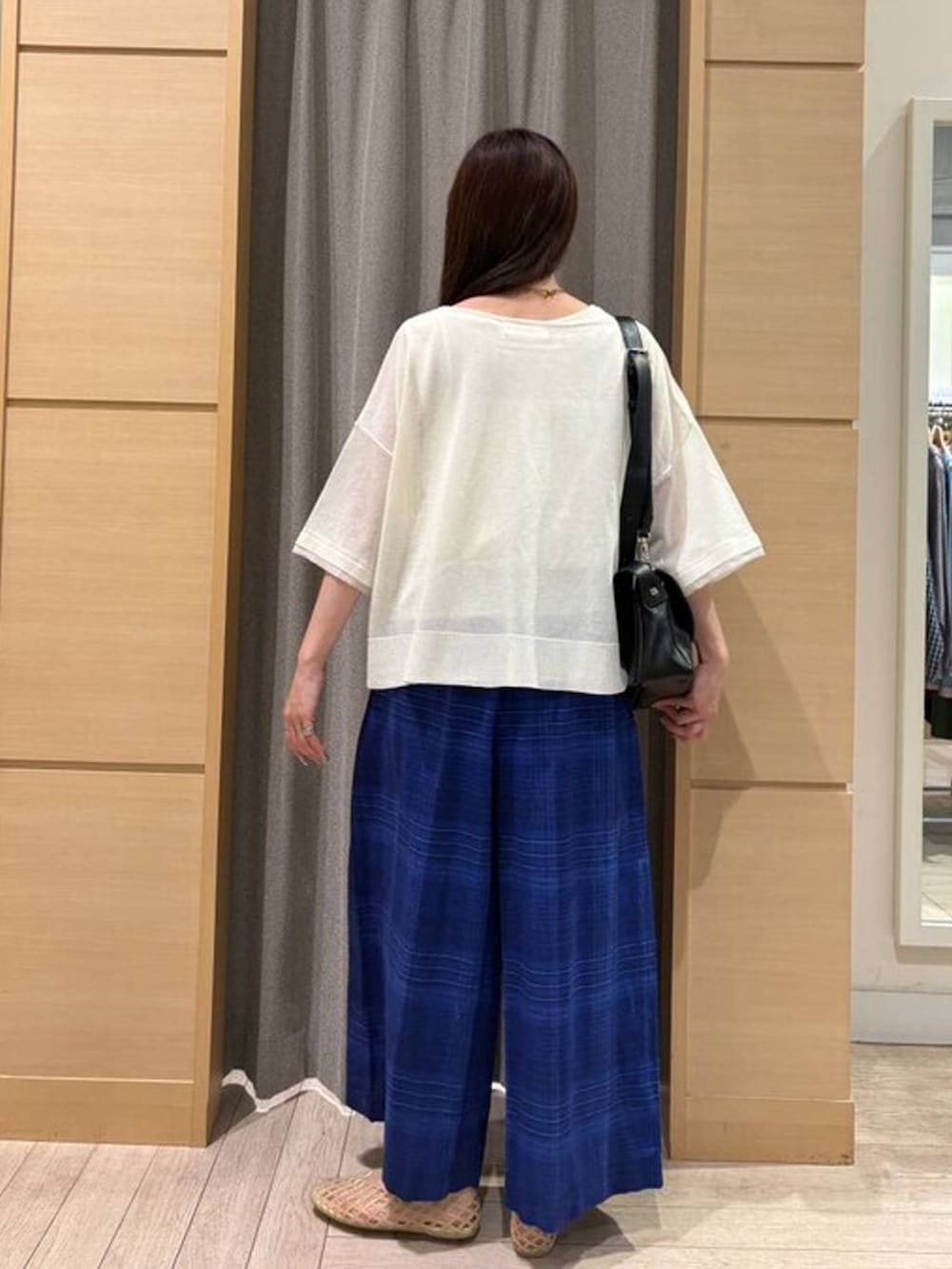 ベージュ系のパンプス、ブルー系のその他パンツ、ブラック系のショルダーバッグを着用したレディースの夏コーディネートの3枚目の写真