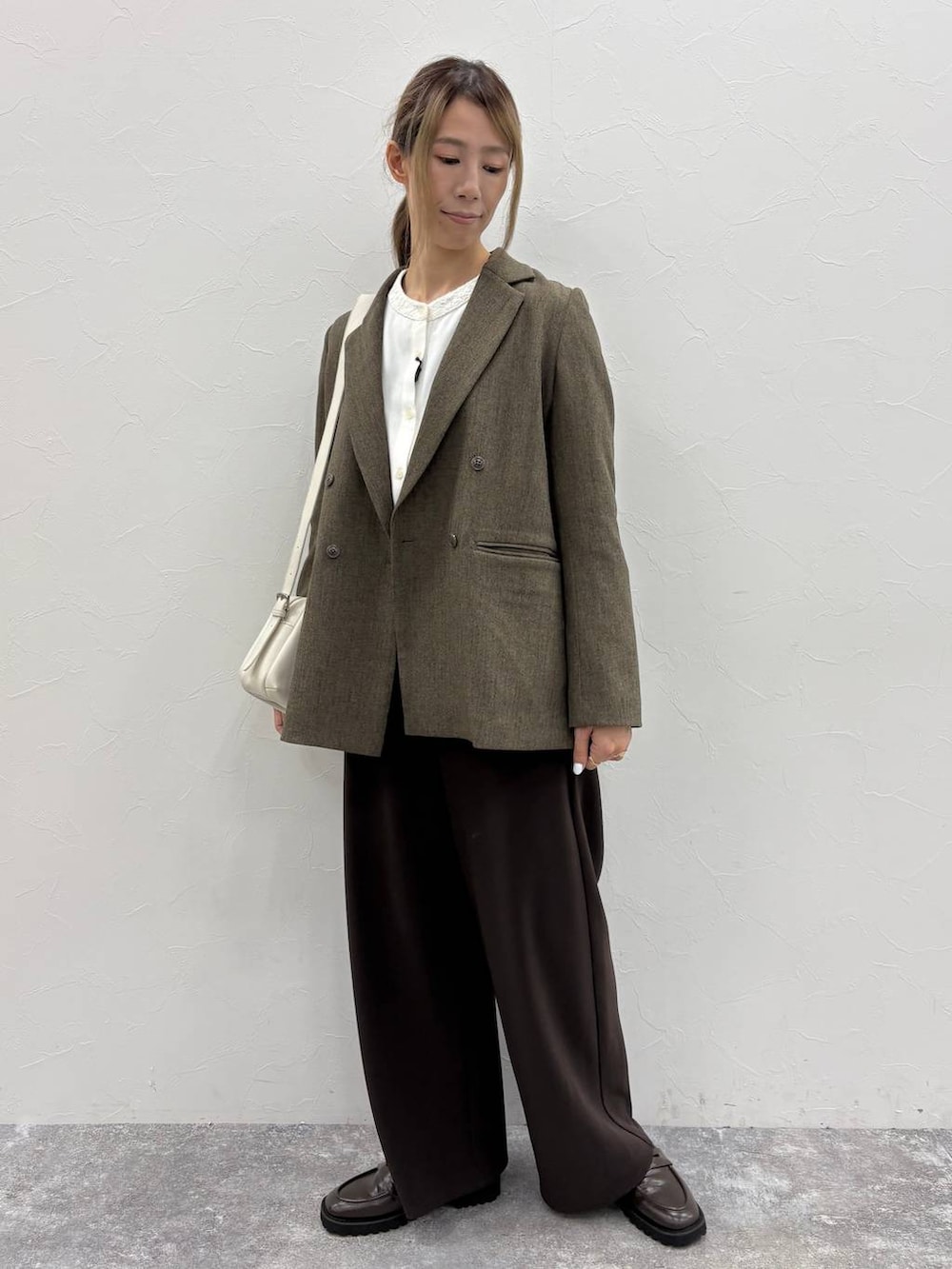 ブラウン系のテーラードジャケット、ホワイト系のシャツ/ブラウス、ブラウン系のローファーを着用したレディースの秋コーディネートの8枚目の写真