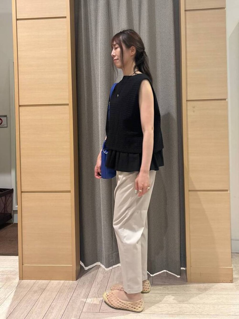 ベージュ系のその他パンツ、ベージュ系のパンプス、ブルー系のショルダーバッグを着用したレディースの夏コーディネートの3枚目の写真