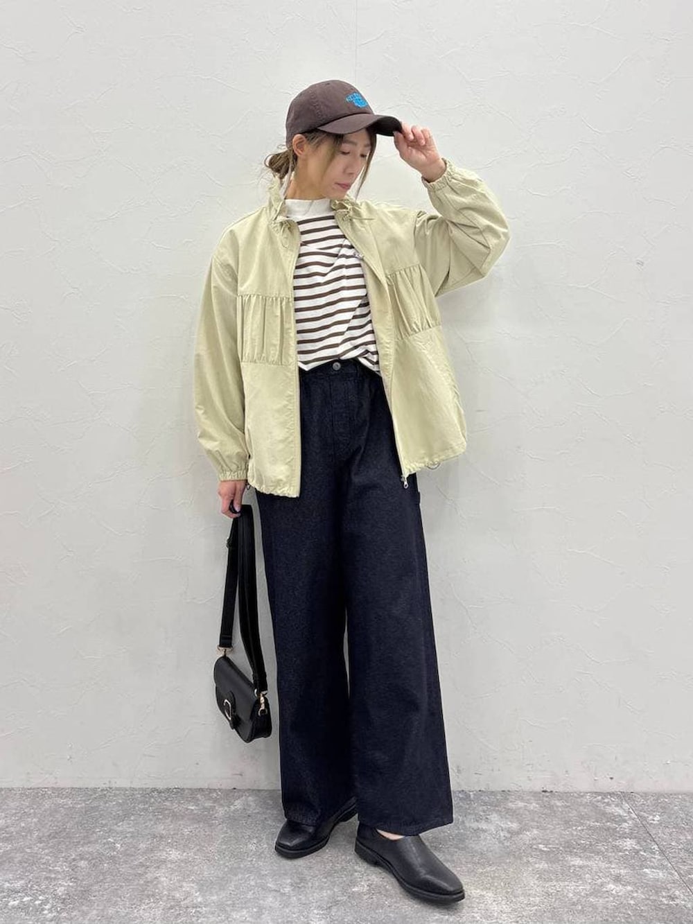 ブラック系のスリッポン、ブラック系のショルダーバッグ、ブルー系のその他パンツを着用したレディースの春コーディネートの2枚目の写真