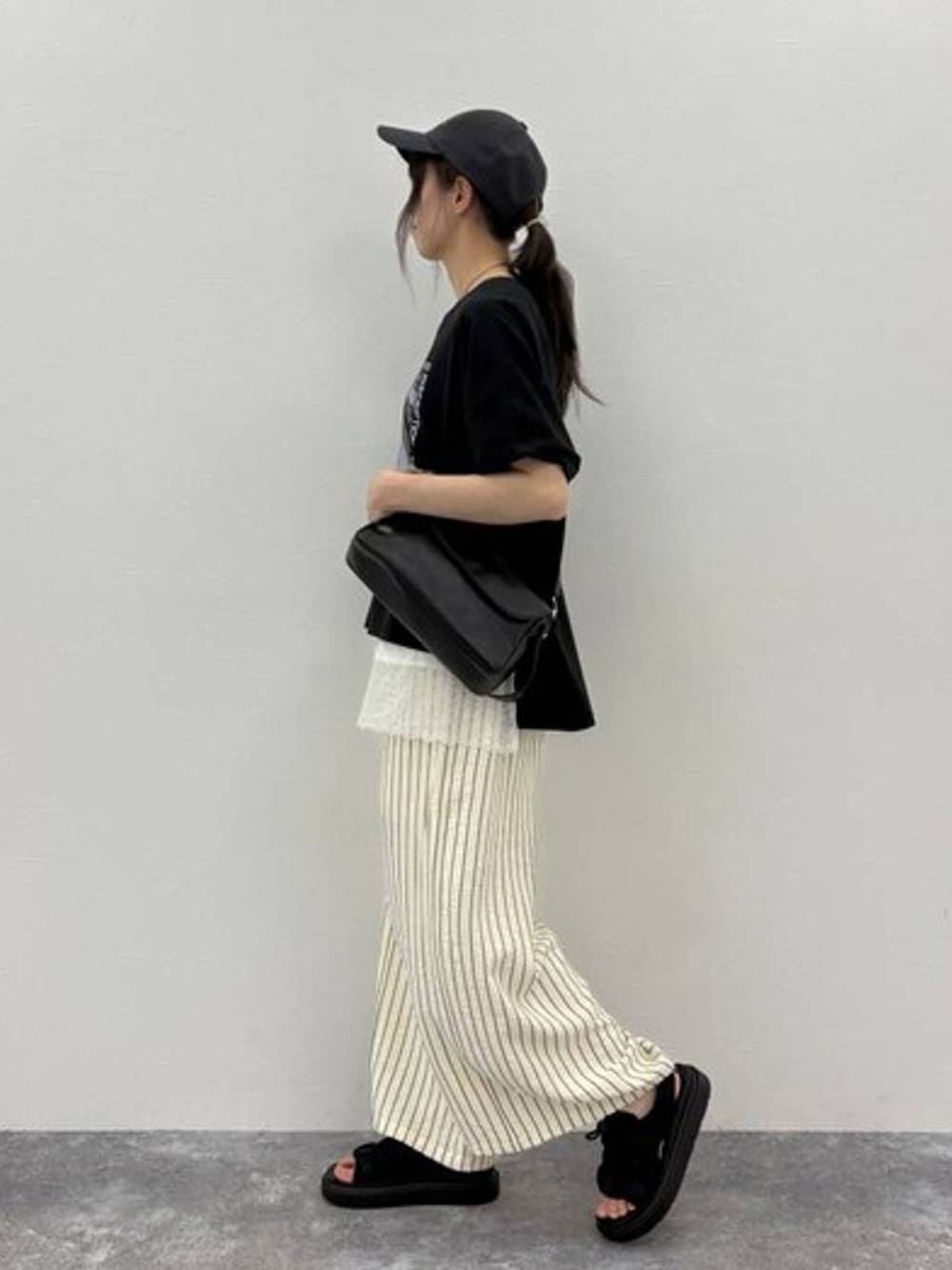 ブラック系のサンダル、ブラック系のTシャツ/カットソー、ブラック系のショルダーバッグを着用したレディースの夏コーディネートの4枚目の写真