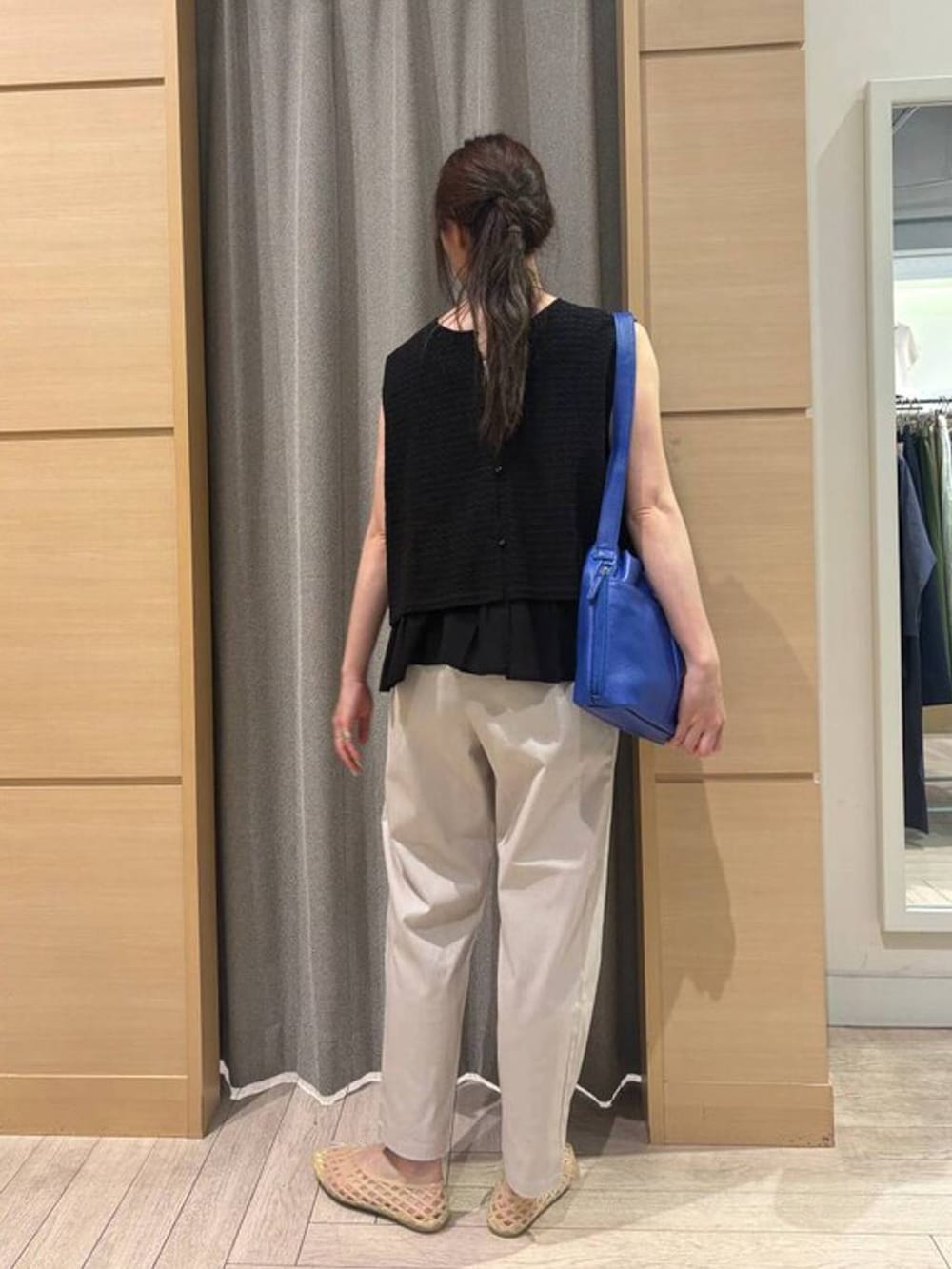 ベージュ系のその他パンツ、ベージュ系のパンプス、ブルー系のショルダーバッグを着用したレディースの夏コーディネートの2枚目の写真