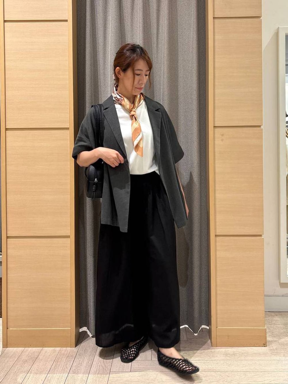 ブラック系のショルダーバッグ、グレー系のテーラードジャケット、ブラック系のその他パンツを着用したレディースの秋コーディネートの4枚目の写真