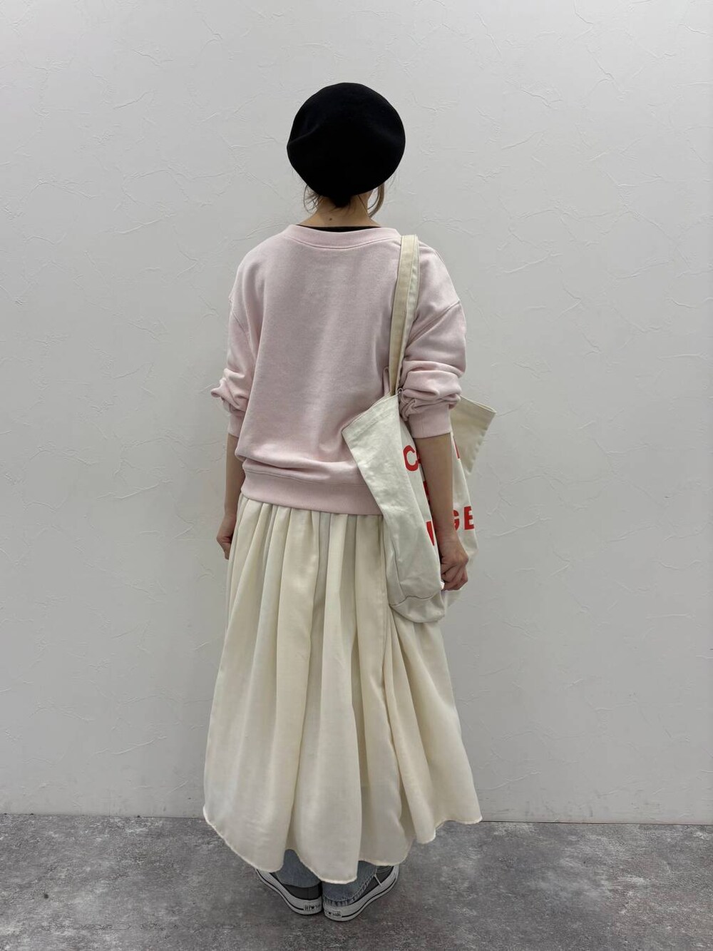 ブラック系のTシャツ/カットソー、ベージュ系のスカート、ブルー系のデニムパンツを着用したレディースの冬コーディネートの4枚目の写真