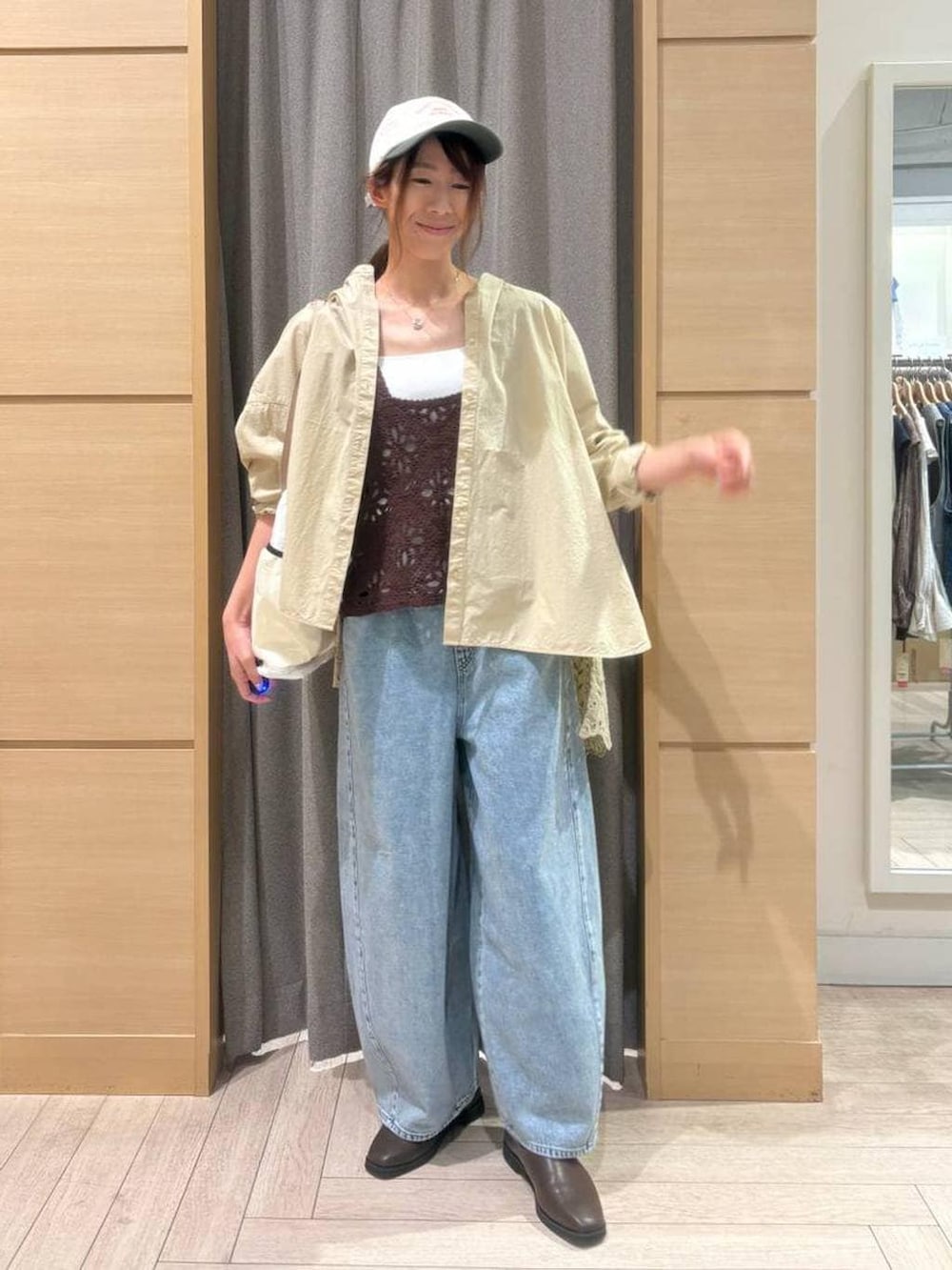 ブラウン系のベスト、ブルー系のデニムパンツ、ブラウン系のスリッポンを着用したレディースの春コーディネートの3枚目の写真