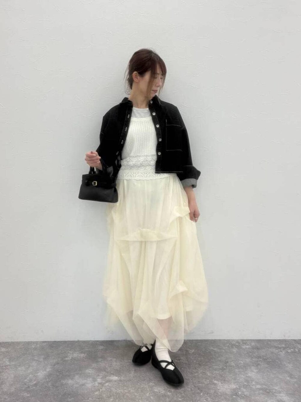 ブラック系のショルダーバッグ、ブラック系のバレエシューズ、ブラック系のデニムジャケットを着用したレディースの春コーディネートの5枚目の写真