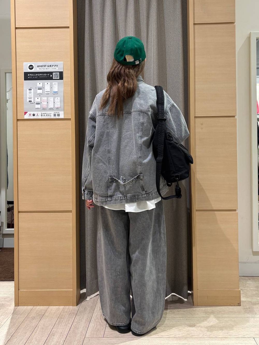 ブラック系のサンダル、グレー系のデニムパンツ、ブラック系のショルダーバッグを着用したレディースの冬コーディネートの3枚目の写真