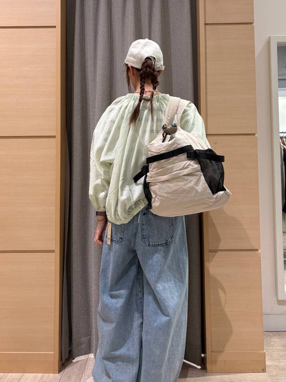ブルー系のデニムパンツ、ベージュ系のショルダーバッグ、その他のニット/セーターを着用したレディースの春コーディネートの2枚目の写真