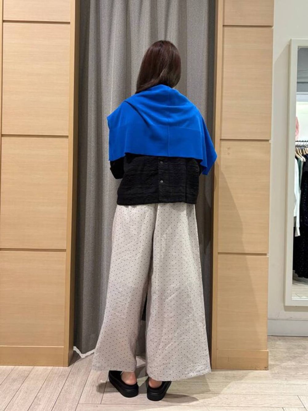 ブルー系のカーディガン/ボレロ、ブラック系のサンダル、ベージュ系のトートバッグを着用したレディースの春コーディネートの2枚目の写真