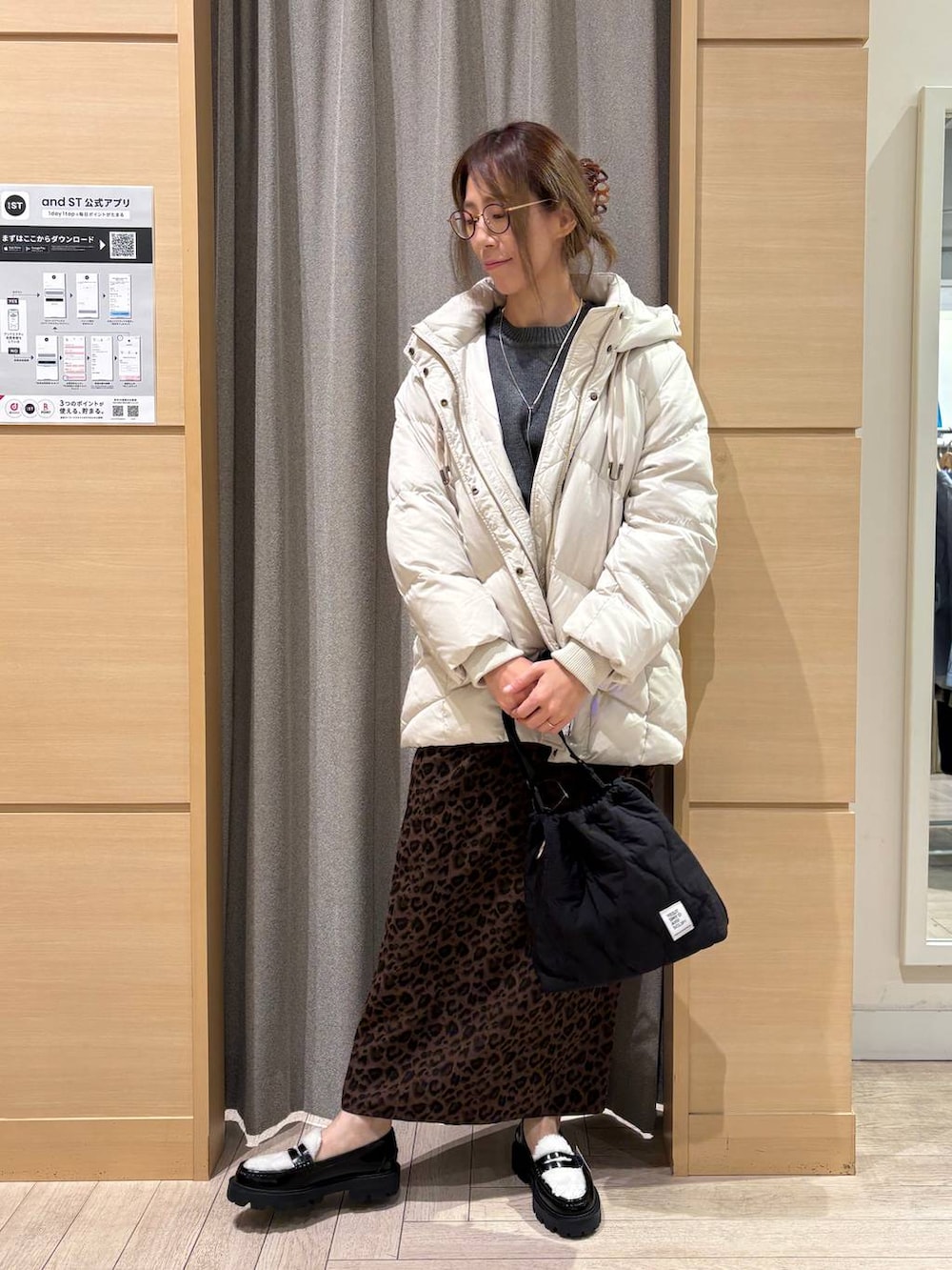 ブラック系のローファー、グレー系のダウンジャケット/コート、ブラック系のショルダーバッグを着用したレディースの冬コーディネートの3枚目の写真