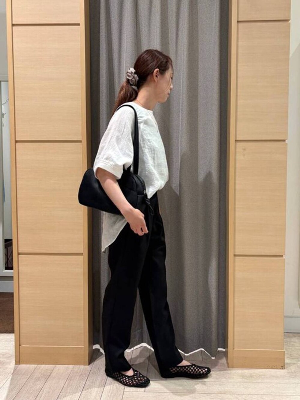 ブラック系のショルダーバッグ、ブラック系のその他パンツ、ホワイト系のシャツ/ブラウスを着用したレディースの夏コーディネートの2枚目の写真
