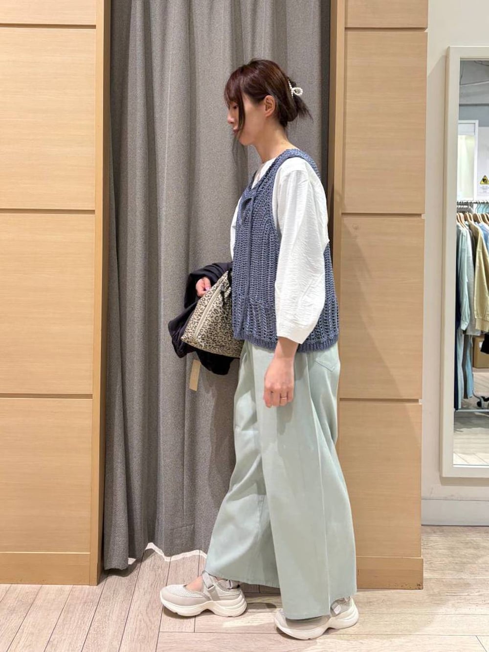 ベージュ系のショルダーバッグ、ブルー系のその他パンツ、ベージュ系のスニーカーを着用したレディースの春コーディネートの5枚目の写真