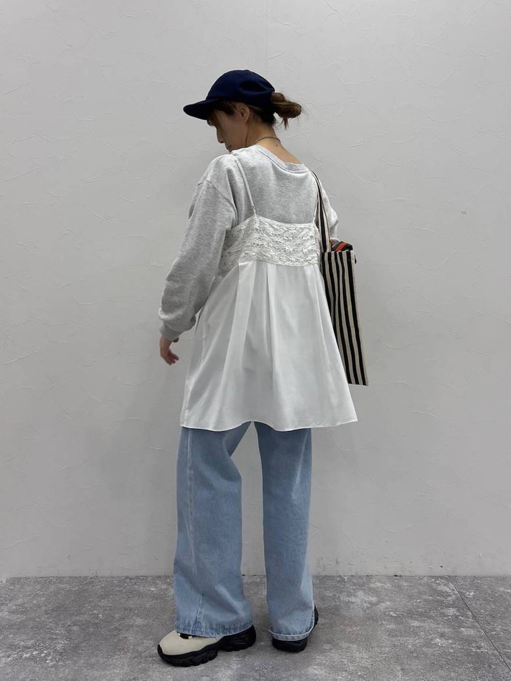 ホワイト系のスニーカー、グレー系のスウェット、ベージュ系のトートバッグを着用したレディースの春コーディネートの3枚目の写真