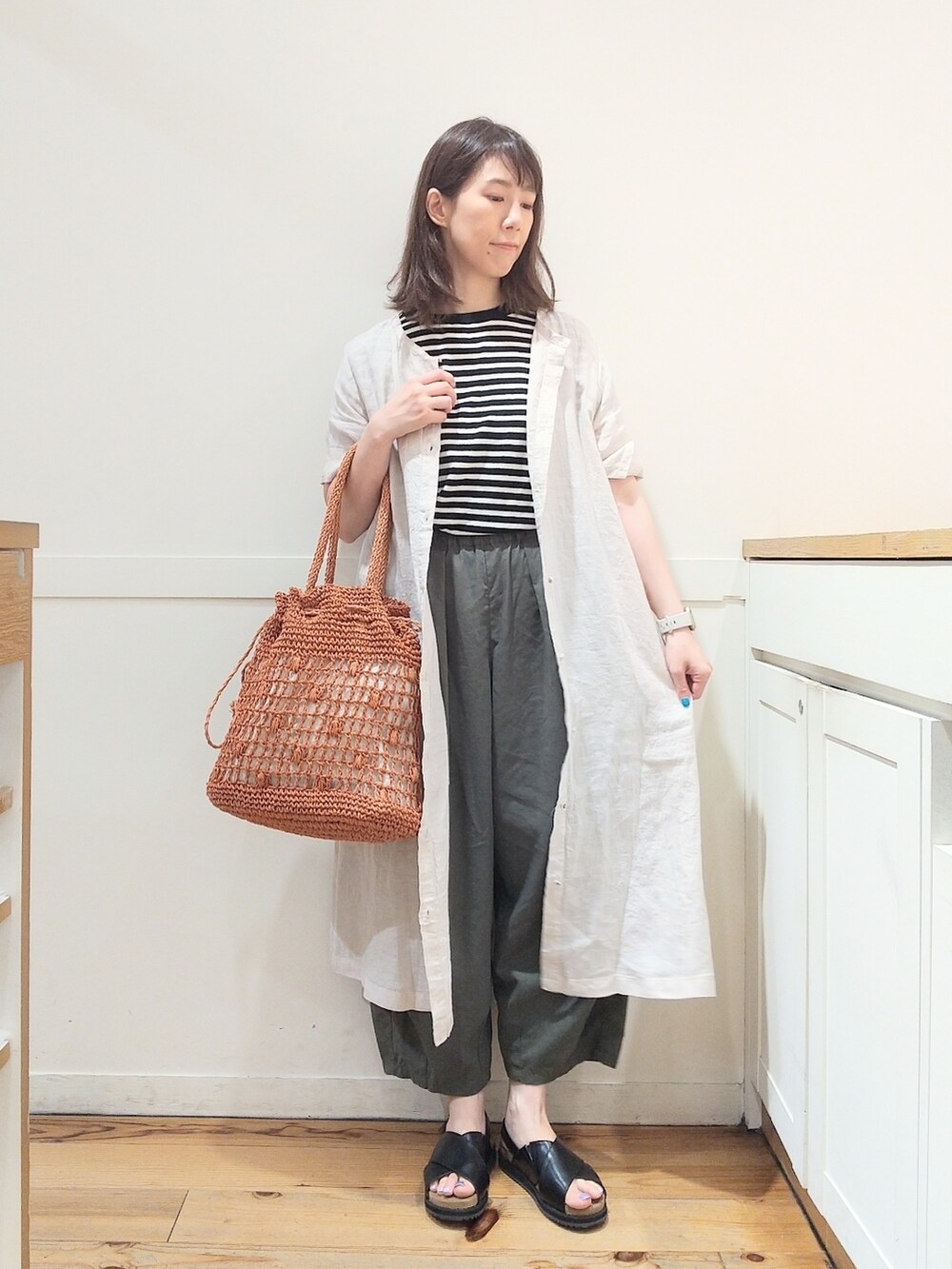 ブラック系のサンダル、ベージュ系のワンピース、ブラック系のニット/セーターを着用したレディースの夏コーディネートの3枚目の写真