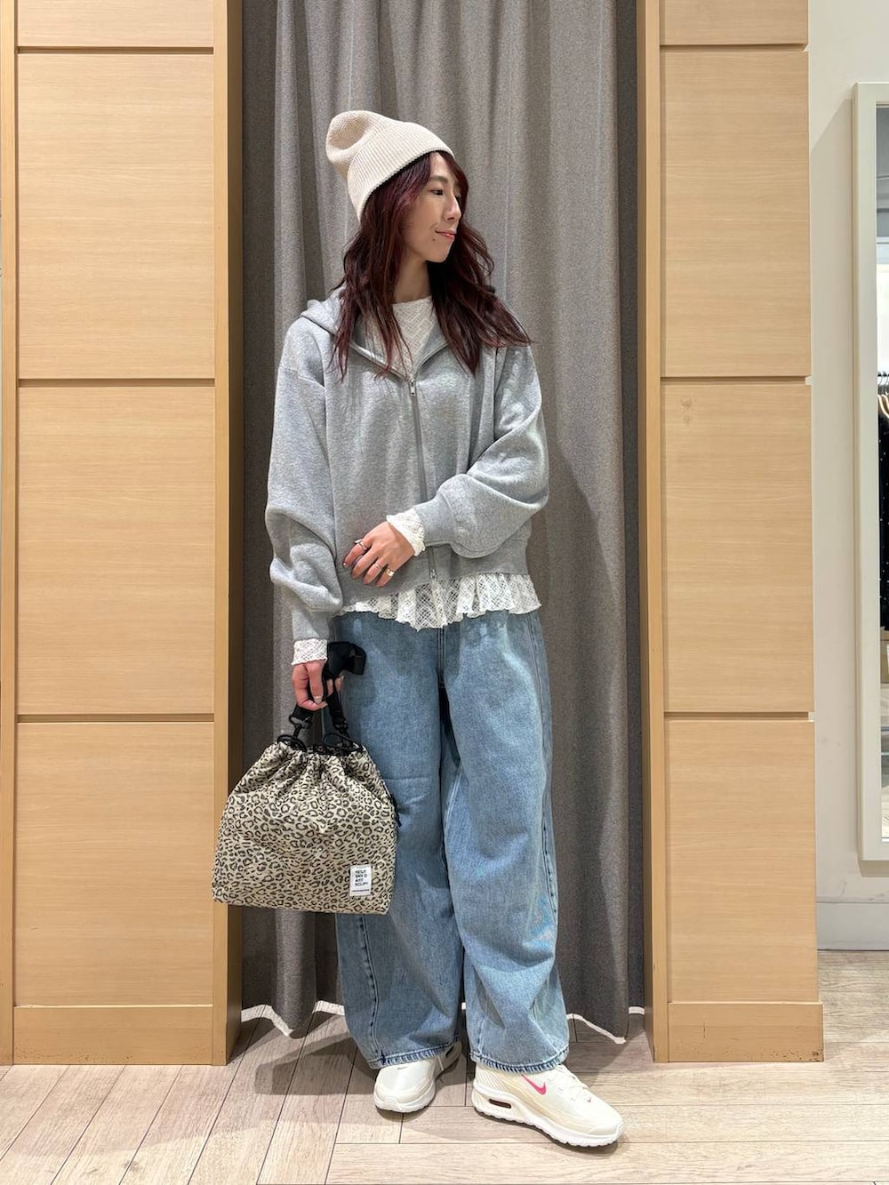 ブルー系のデニムパンツ、ベージュ系のショルダーバッグ、ホワイト系のTシャツ/カットソーを着用したレディースの春コーディネートの4枚目の写真