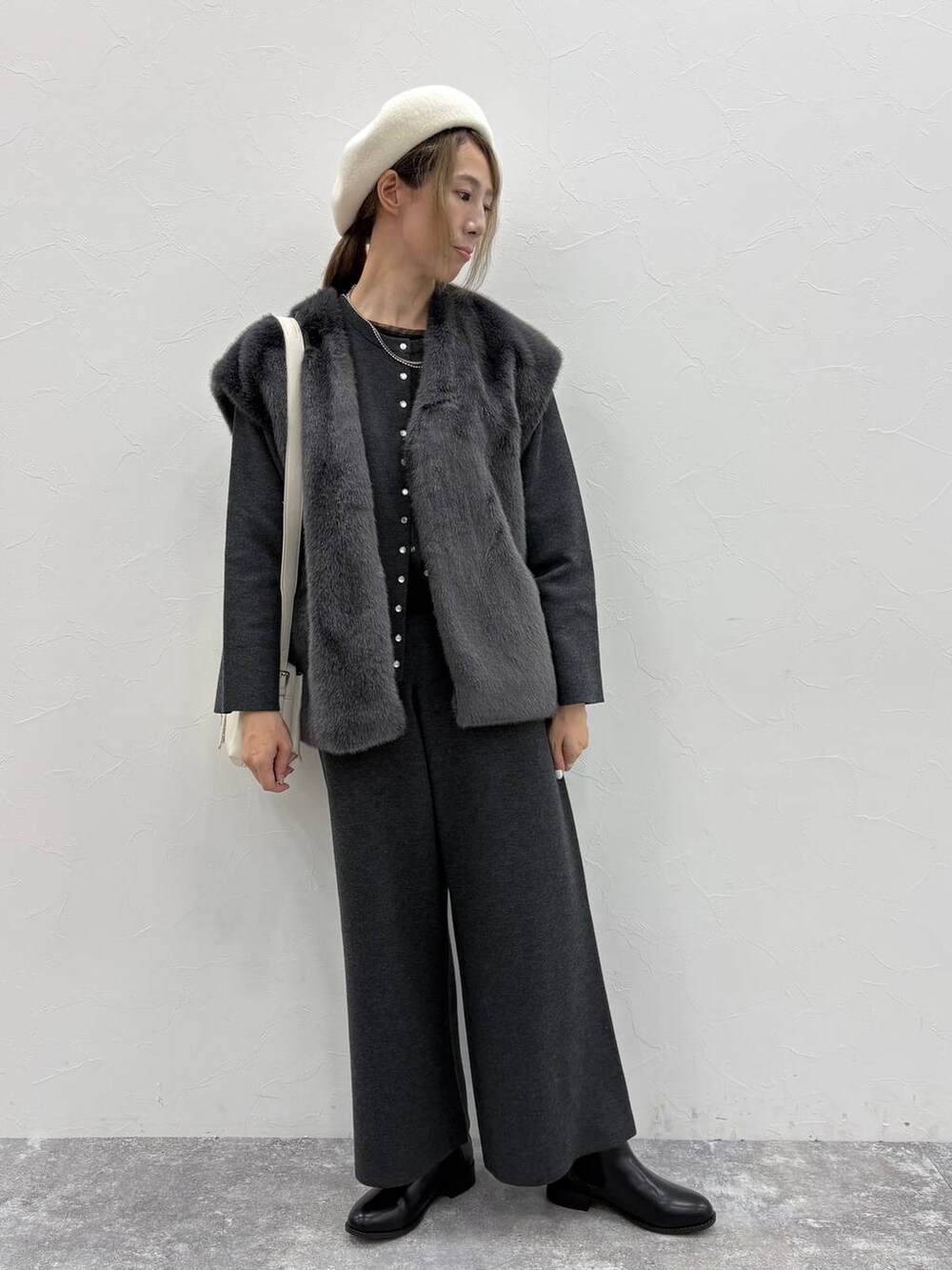 ブラック系のブーツ、ブラック系のTシャツ/カットソー、ベージュ系のショルダーバッグを着用したレディースの秋コーディネートの4枚目の写真