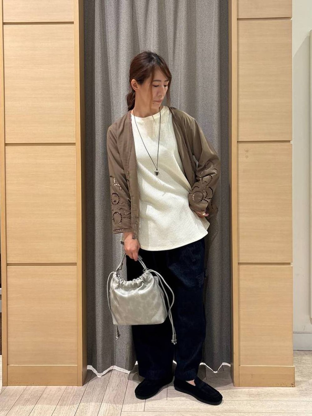 グレー系のショルダーバッグ、ブラウン系のシャツ/ブラウス、ブルー系のデニムパンツを着用したレディースの秋コーディネートの3枚目の写真