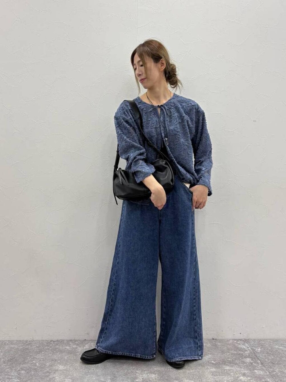 ブラック系のTシャツ/カットソー、ブルー系のデニムパンツ、ブラック系のローファーを着用したレディースの春コーディネートの6枚目の写真