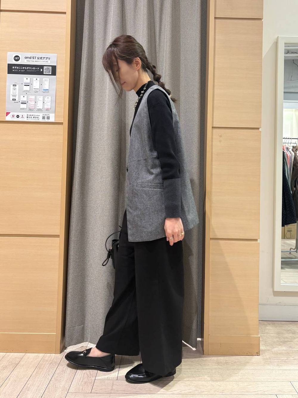 グレー系のベスト、その他のニット/セーター、ブラック系のスラックスを着用したレディースの春コーディネートの2枚目の写真