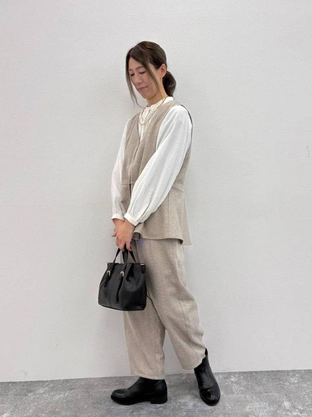 ホワイト系のシャツ/ブラウス、ブラック系のブーツ、ブラック系のショルダーバッグを着用したレディースの冬コーディネートの2枚目の写真