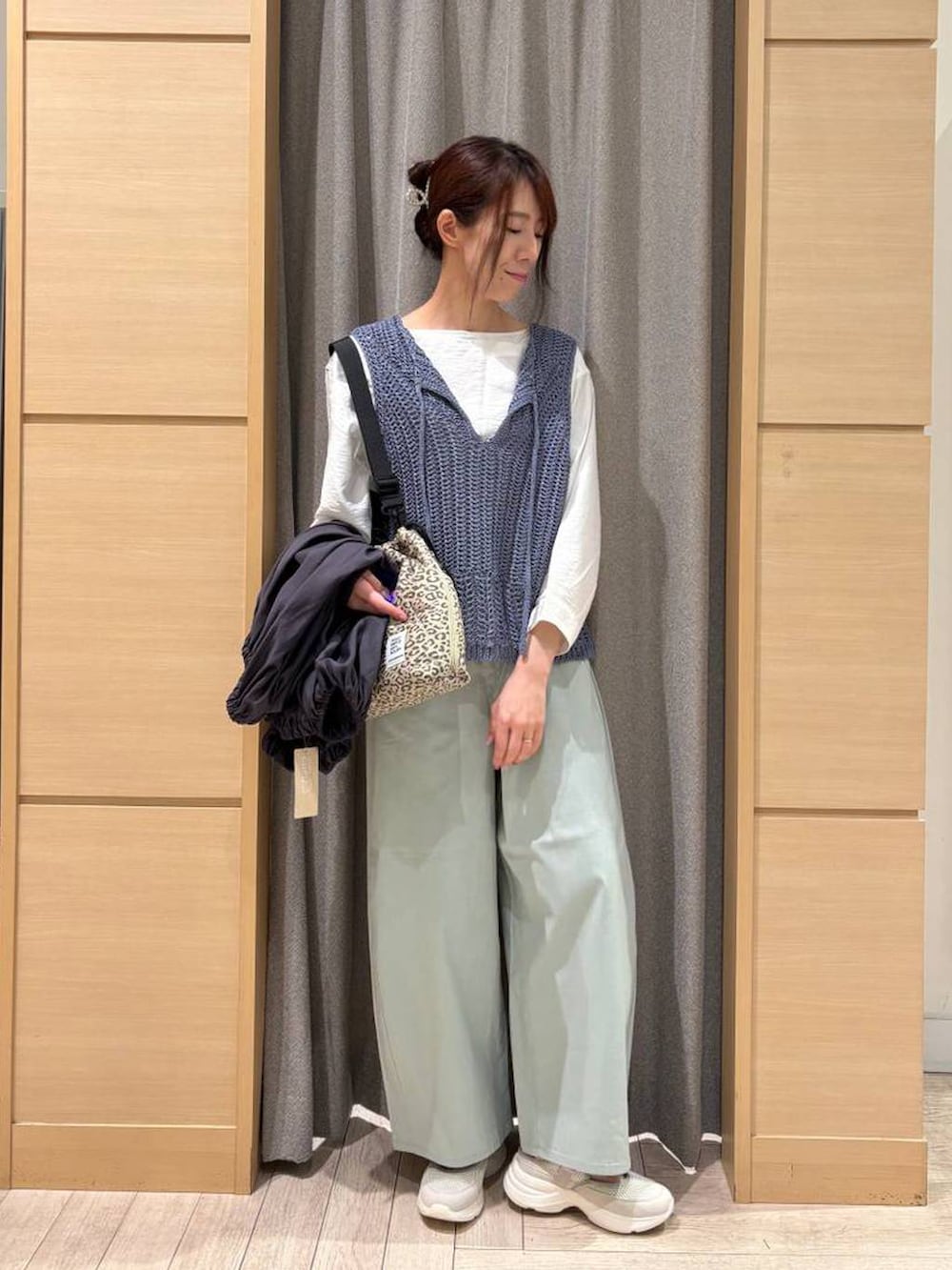 ベージュ系のショルダーバッグ、ブルー系のその他パンツ、ベージュ系のスニーカーを着用したレディースの春コーディネートの3枚目の写真
