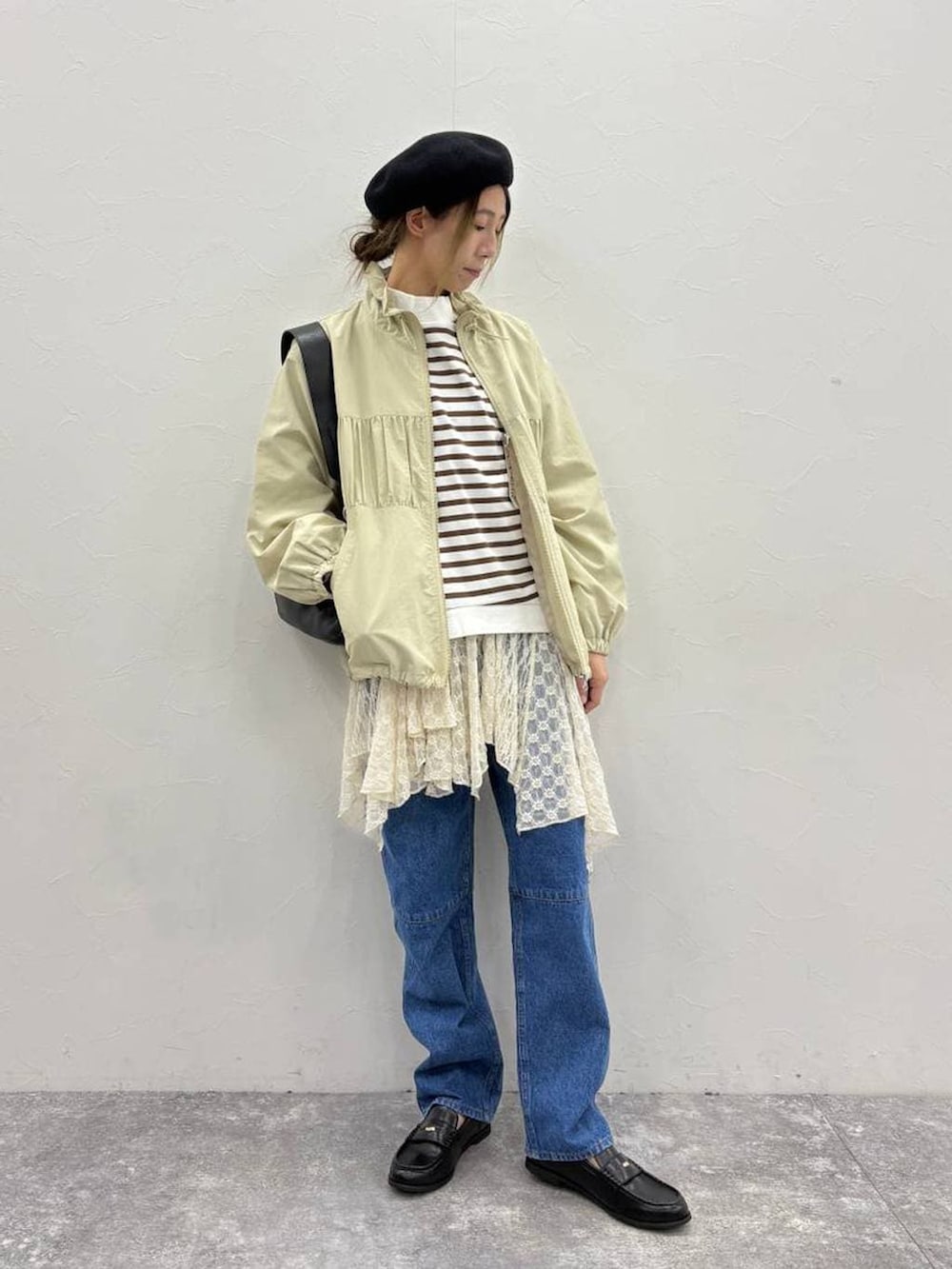 ブラック系のトートバッグ、ブラック系のローファー、ベージュ系のワンピースを着用したレディースの春コーディネートの3枚目の写真