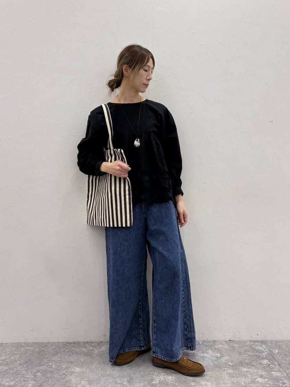 ブルー系のデニムパンツ、イエロー系のローファー、イエロー系のトートバッグを着用したレディースの春コーディネートの5枚目の写真