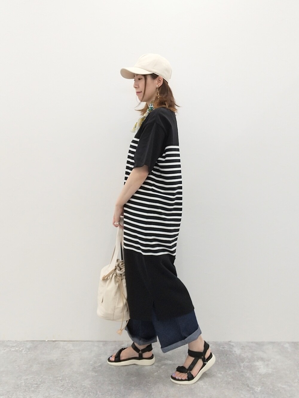 ブラック系のワンピース、ブルー系のデニムパンツ、ブラック系のサンダルを着用したレディースの夏コーディネートの3枚目の写真